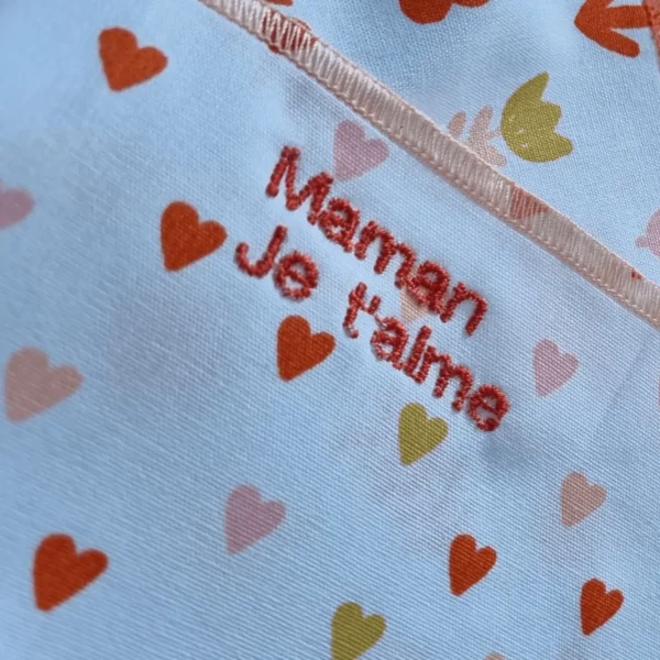 Détail de la broderie « Maman je t’aime » sur mouchoir en tissu lavable