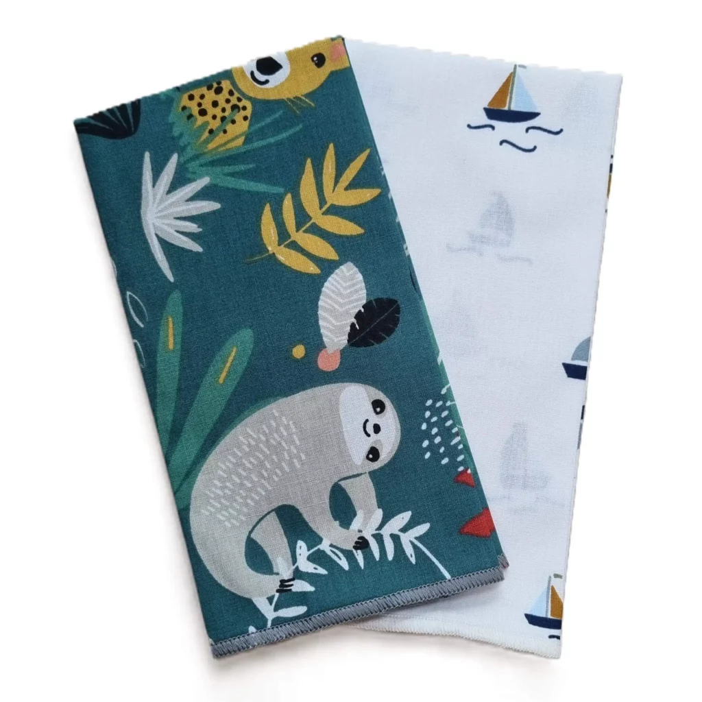 Mouchoir plié 35x35 cm en tissu certifié Oeko-Tex, réutilisable et compact. Motif savane et bateaux.